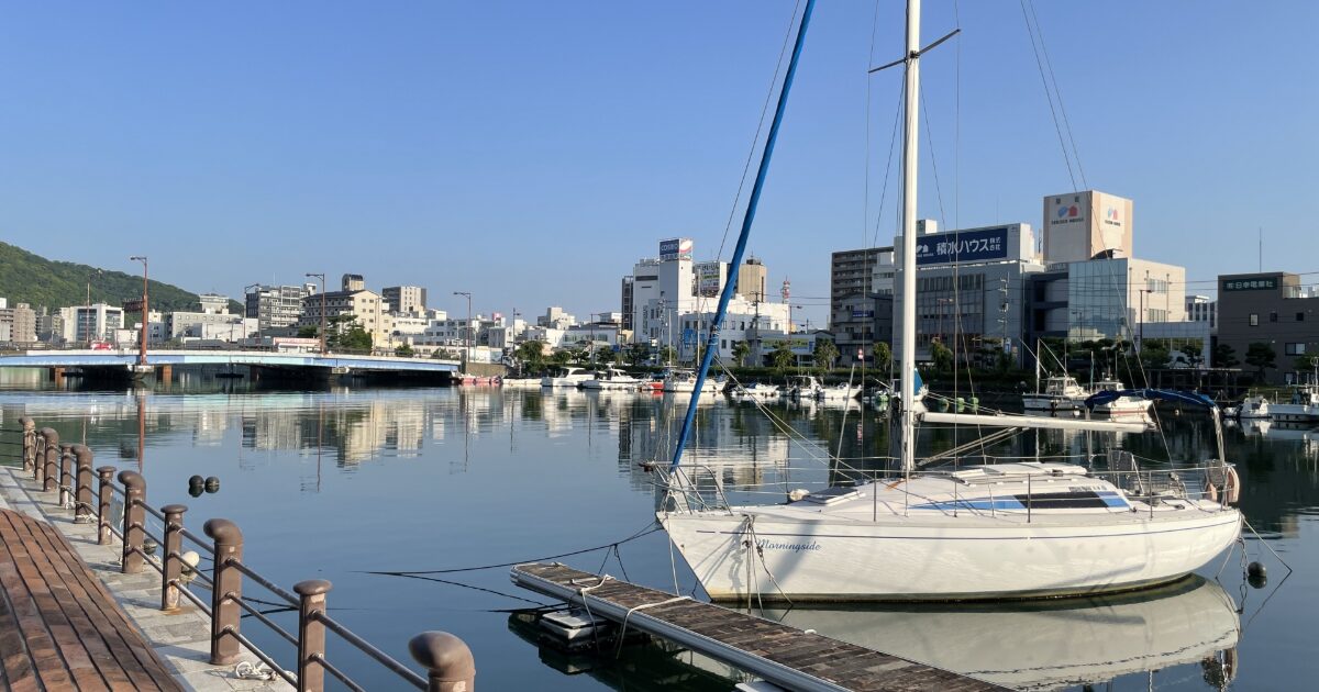 徳島市の河川沿いに停泊するヨットと都市風景