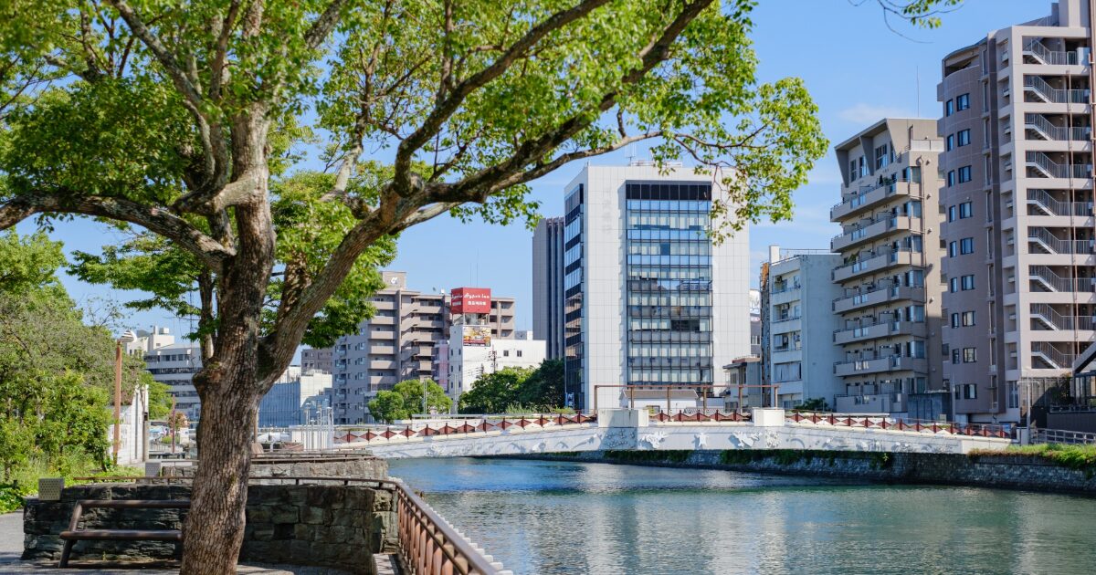 川沿いの遊歩道と橋と都市ビルが並ぶ景観