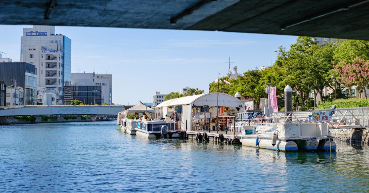 徳島の川沿いに浮かぶカフェとボートの風景